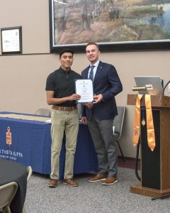 Elian Sanchez receives certificate and is inducted into the Phi Theta Kappa Honor Society