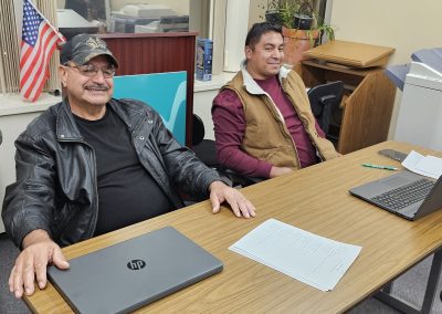 Two students participating in the Project C-3PO basic computer literacy course show off their new laptops