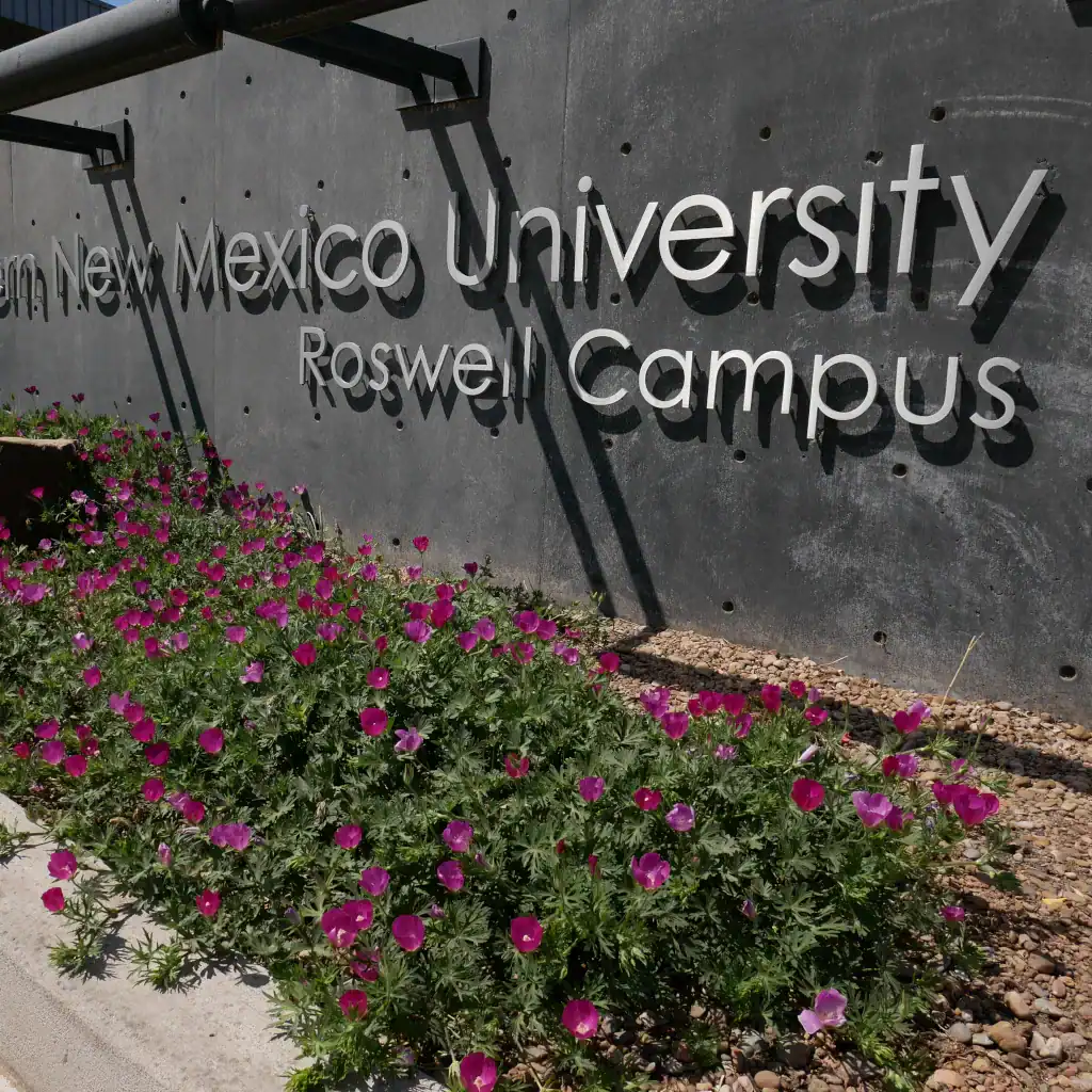 The front sign located at the Student Services Center. In metallic lettering, it reads "Eastern New Mexico University - Roswell Campus".