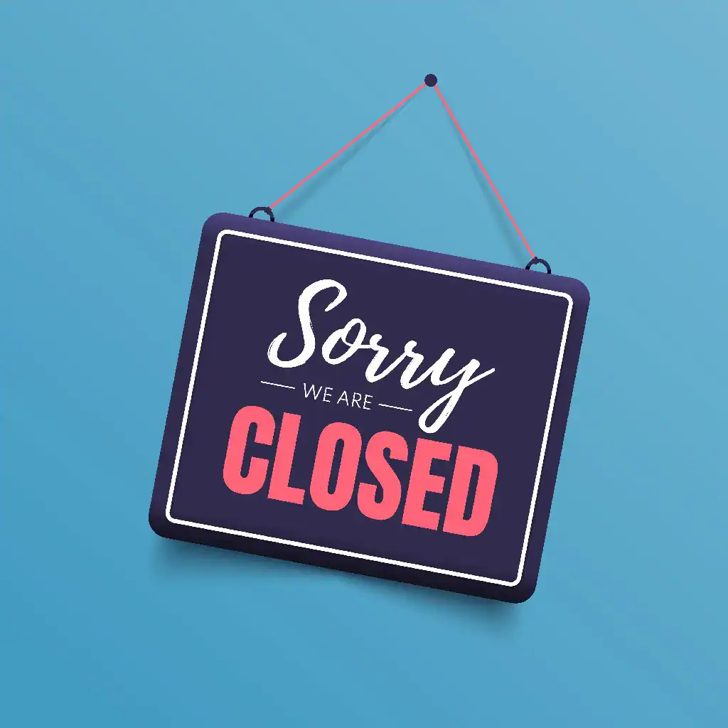 A sign hanging from a nail against a blue background that reads "Sorry, we're closed".