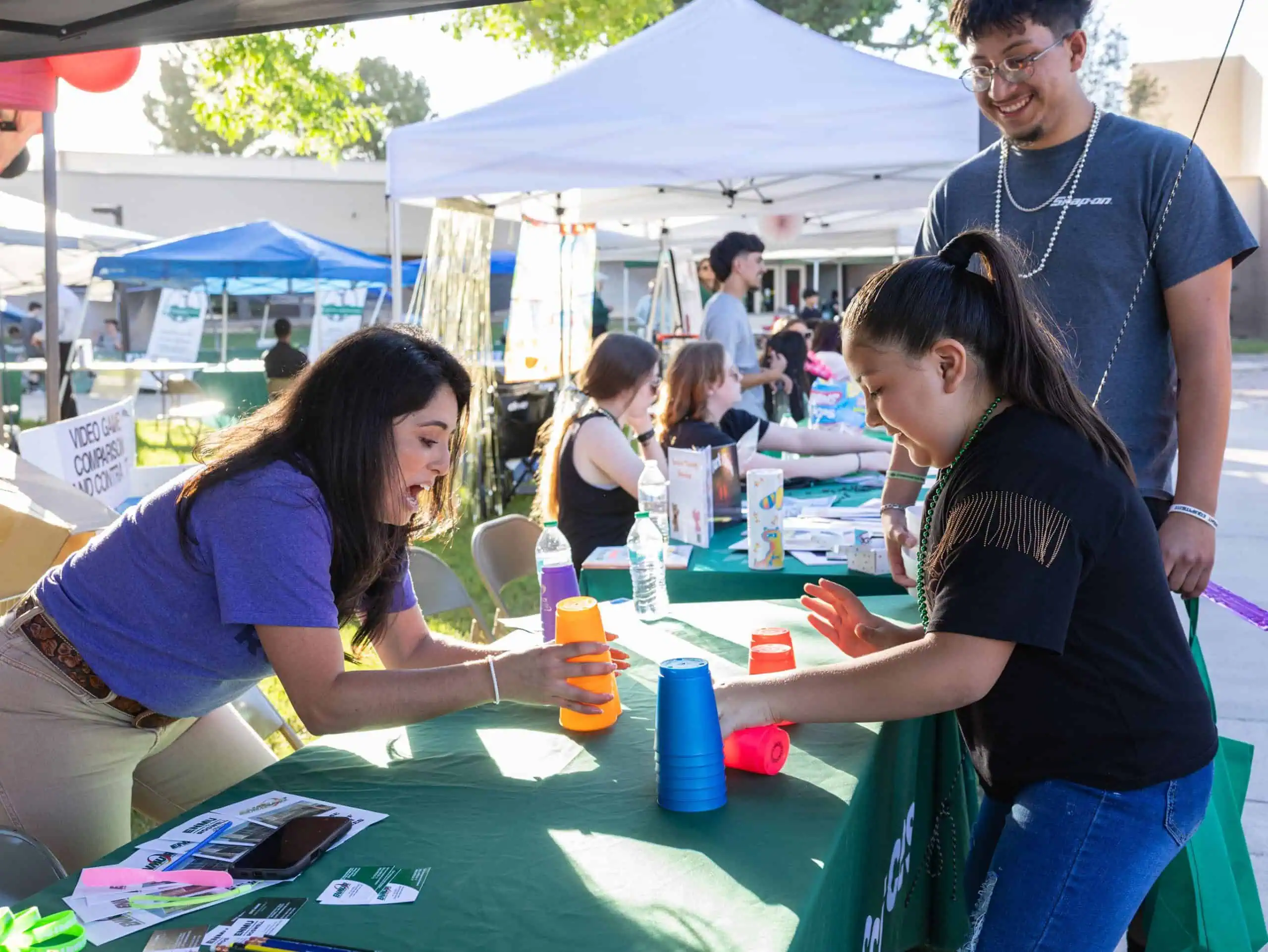 Photo of an ENMU-Roswell OTA instructor demonstrating an agility skill with a child during the 2025 One Eastern Day event.
